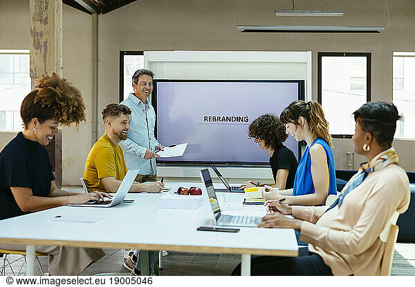 Happy business colleagues discussing in meeting