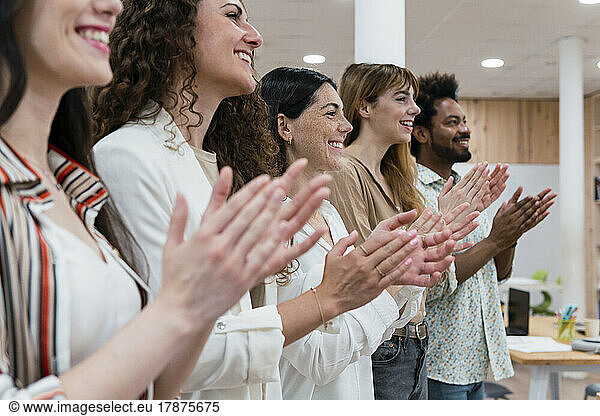 Happy business team clapping hands after a presentation in office