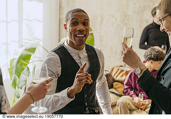 Happy businessman gesturing while discussing with colleagues during event at convention center