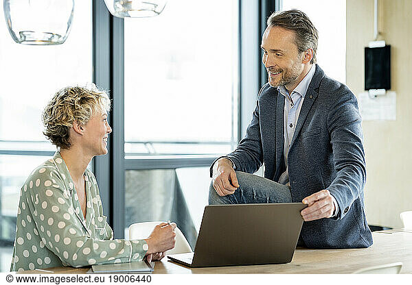 Happy businessman having discussion with businesswoman