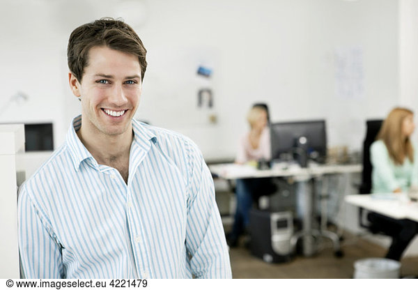 Happy businessman standing in the office