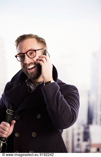 Happy businessman talking on cell phone