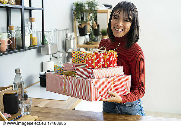 Happy businesswoman carrying gift boxes at home