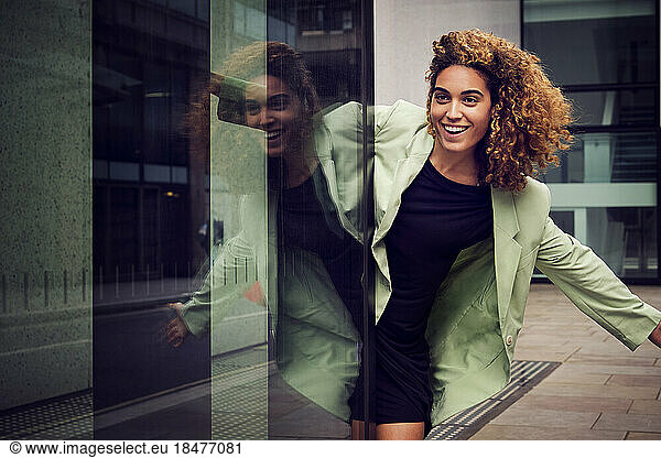 Happy businesswoman enjoying near glass building