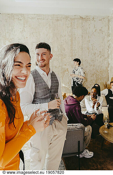 Happy businesswoman laughing by male colleague during event at convention center