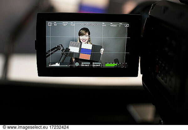 Happy businesswoman showing prototype while recording on digital camera in creative office