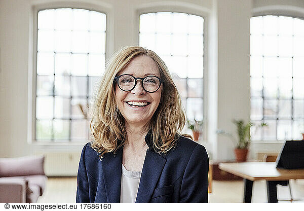 Happy businesswoman wearing eyeglasses at home