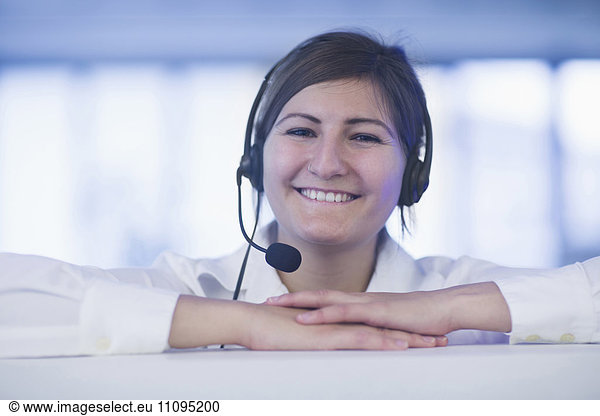Happy businesswoman wearing headset in office  Freiburg Im Breisgau  Baden-Württemberg  Germany