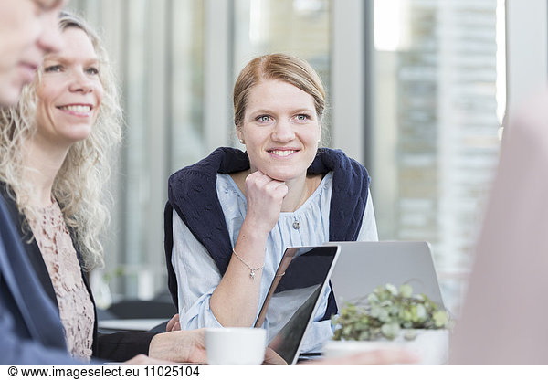 Happy businesswomen sitting in meeting at office