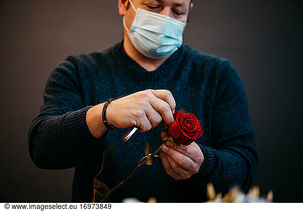 Happy caucasian florist making selling red roses for valentine day