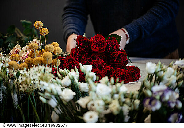 Happy caucasian florist making selling red roses for valentine day