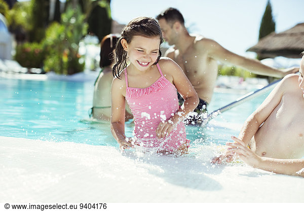Happy children splashing water in swimming pool