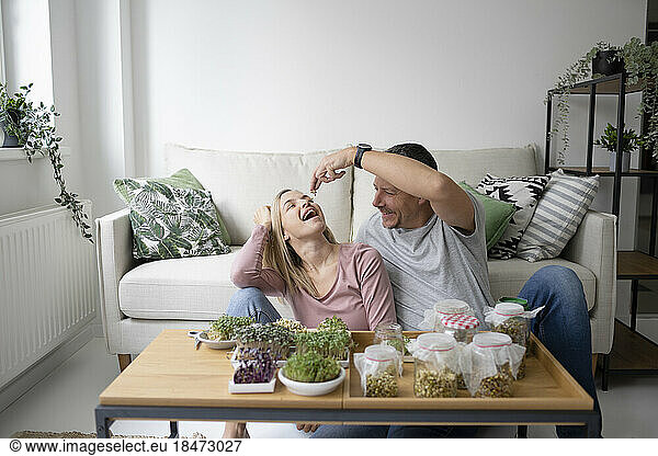 Happy couple eating homegrown herbs at home
