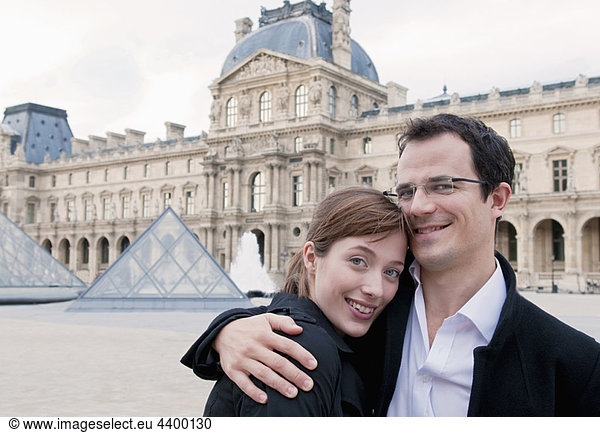 Happy couple embrace outside the Louvre