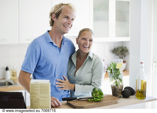 Happy couple embracing in kitchen