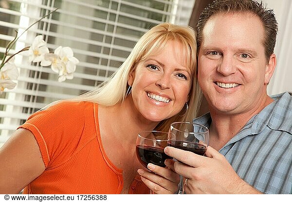 Happy couple enjoying a glass of wine the kitchen