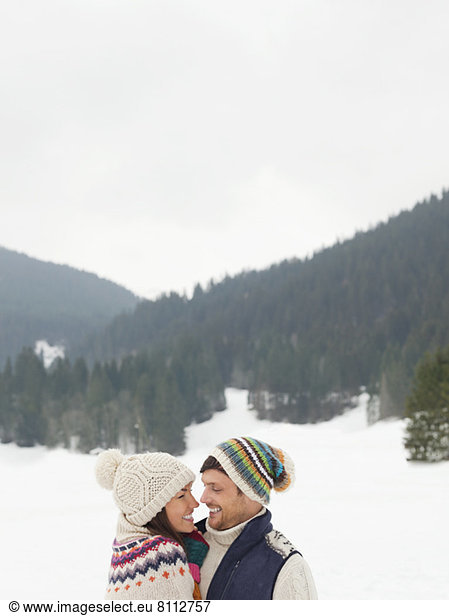 Happy couple face to face in snowy field