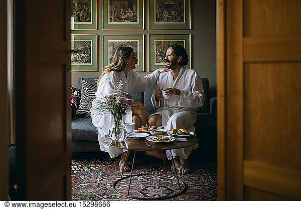 Happy couple in bathrobes in hotel room