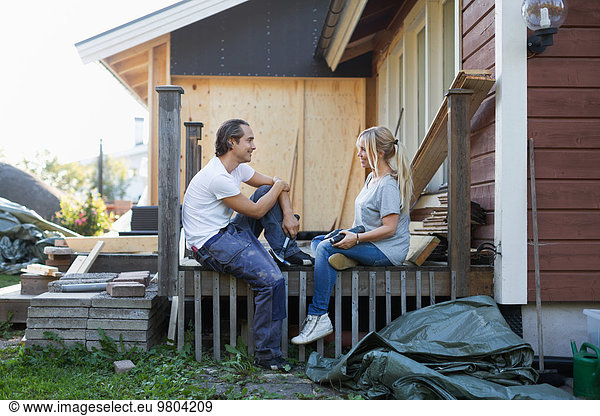 Happy couple looking at each other while renovating house