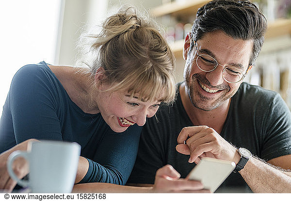 Happy couple looking at smartphone together