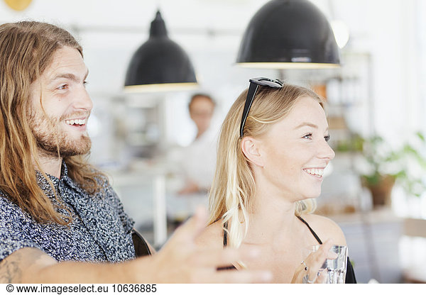 Happy couple looking away in restaurant