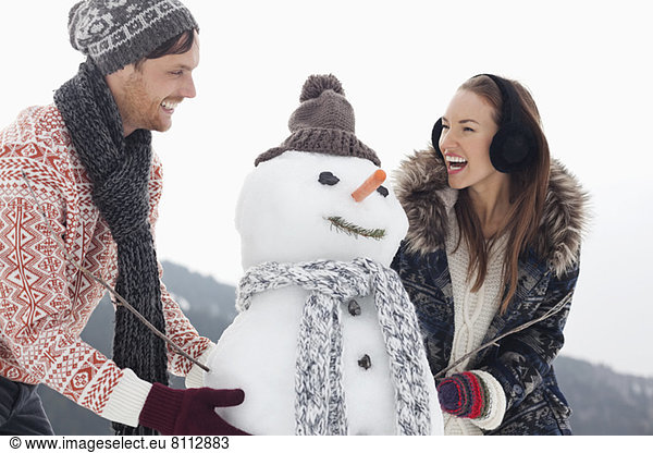 Happy couple making snowman