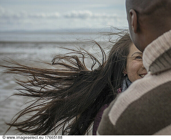 Happy couple on windy winter beach