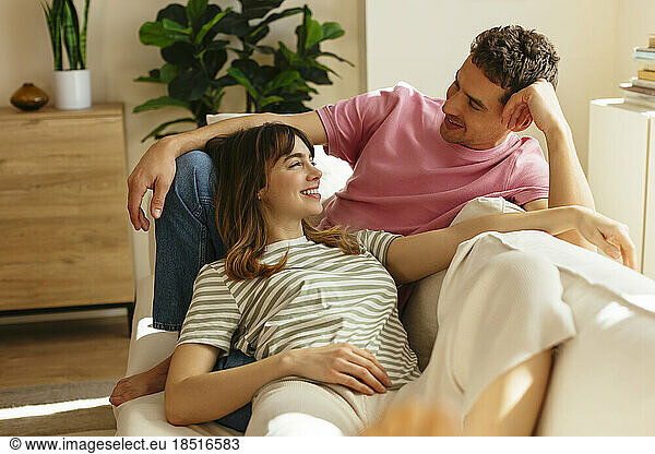 Happy couple relaxing on sofa at home