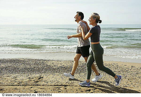 Happy couple running and having fun at beach