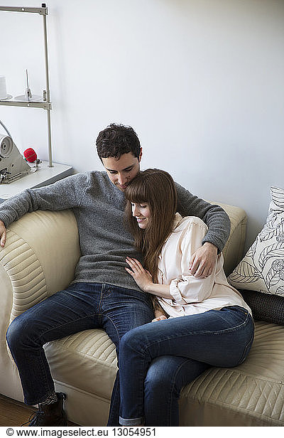 Happy couple sitting on couch at home
