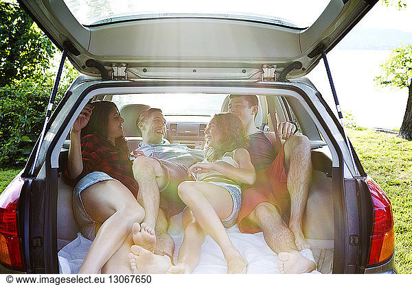 Happy couples relaxing in car trunk