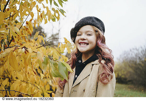 Happy cute girl wearing beret standing in autumn park