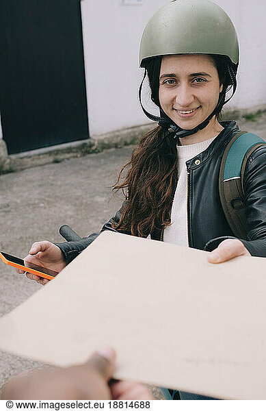 Happy delivery person giving envelope to customer