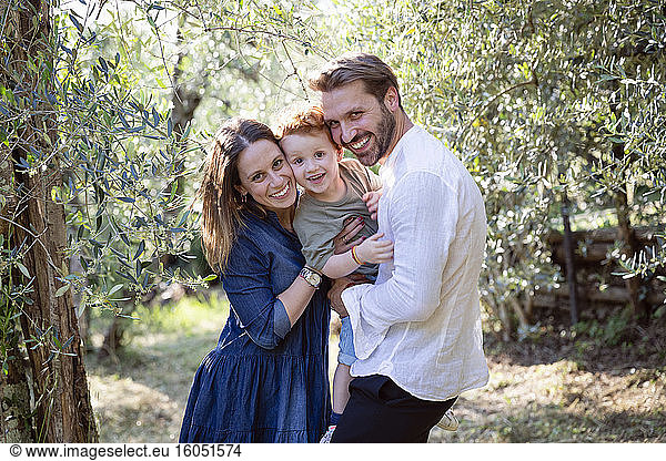 Happy family enjoying against plants at olive orchard