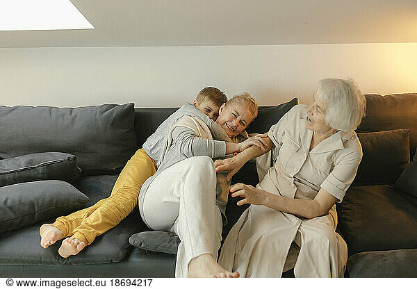 Happy family enjoying together sitting on sofa at home
