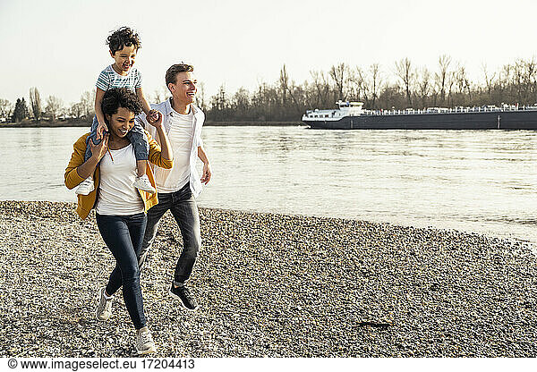 Happy family enjoying while running on pebble during vacations