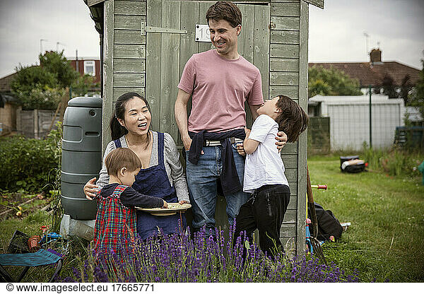 Happy family laughing at garden shed