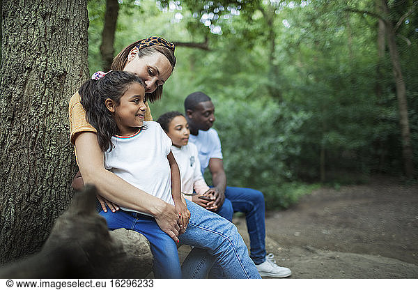 Happy family resting on hike in woods