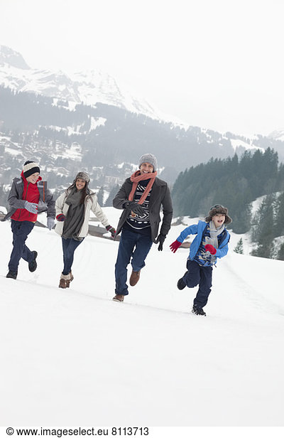 Happy family running in snowy field
