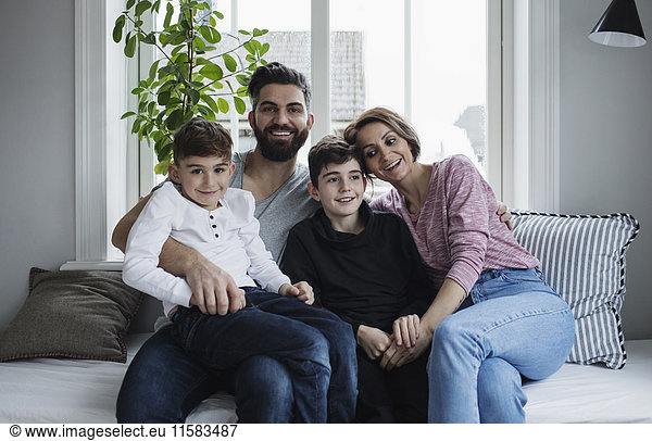 Happy family sitting on sofa in living room at home