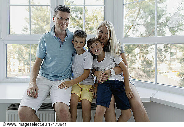 Happy family sitting together at window