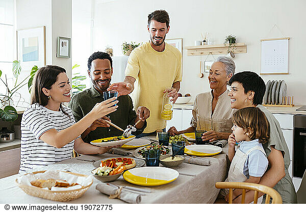 Happy family spending leisure time having lunch in kitchen