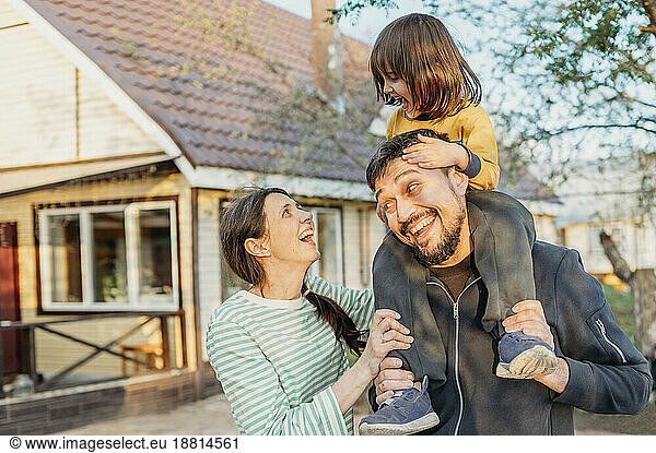 Happy family spending leisure time in front yard
