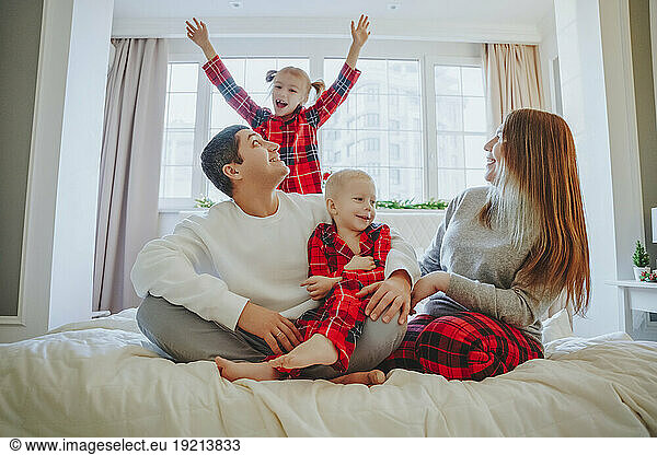 Happy family spending leisure time on bed at home
