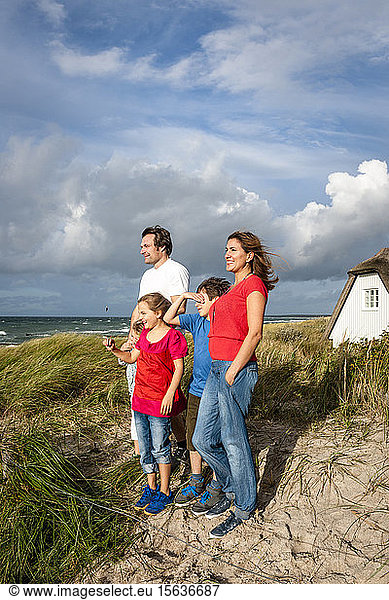 Happy family standing in a beach dune looking at view  Darss  Mecklenburg-Western Pomerania  Germany