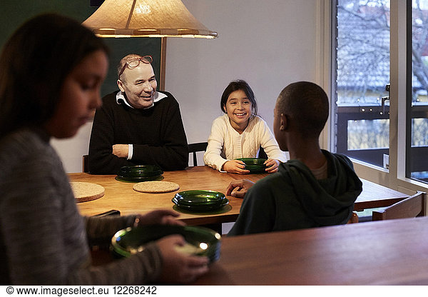 Happy family talking while sitting at illuminated table