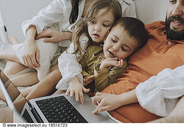Happy family using laptop together at home