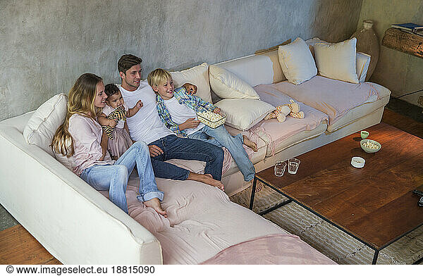 Happy family watching TV together at home
