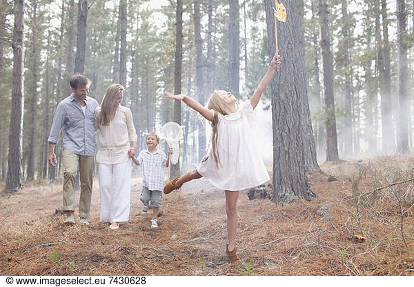 Happy family with butterfly nets in sunny woods