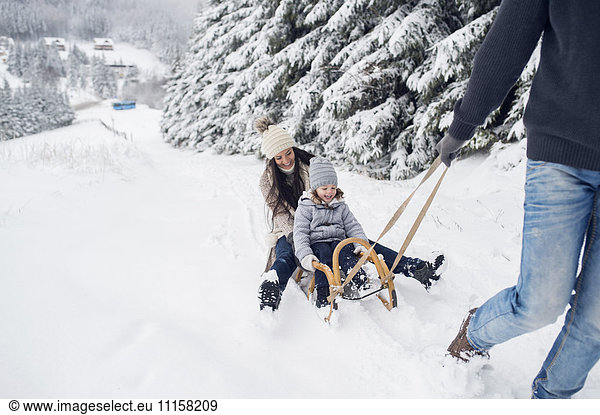 Happy family with sledge in winter landscape